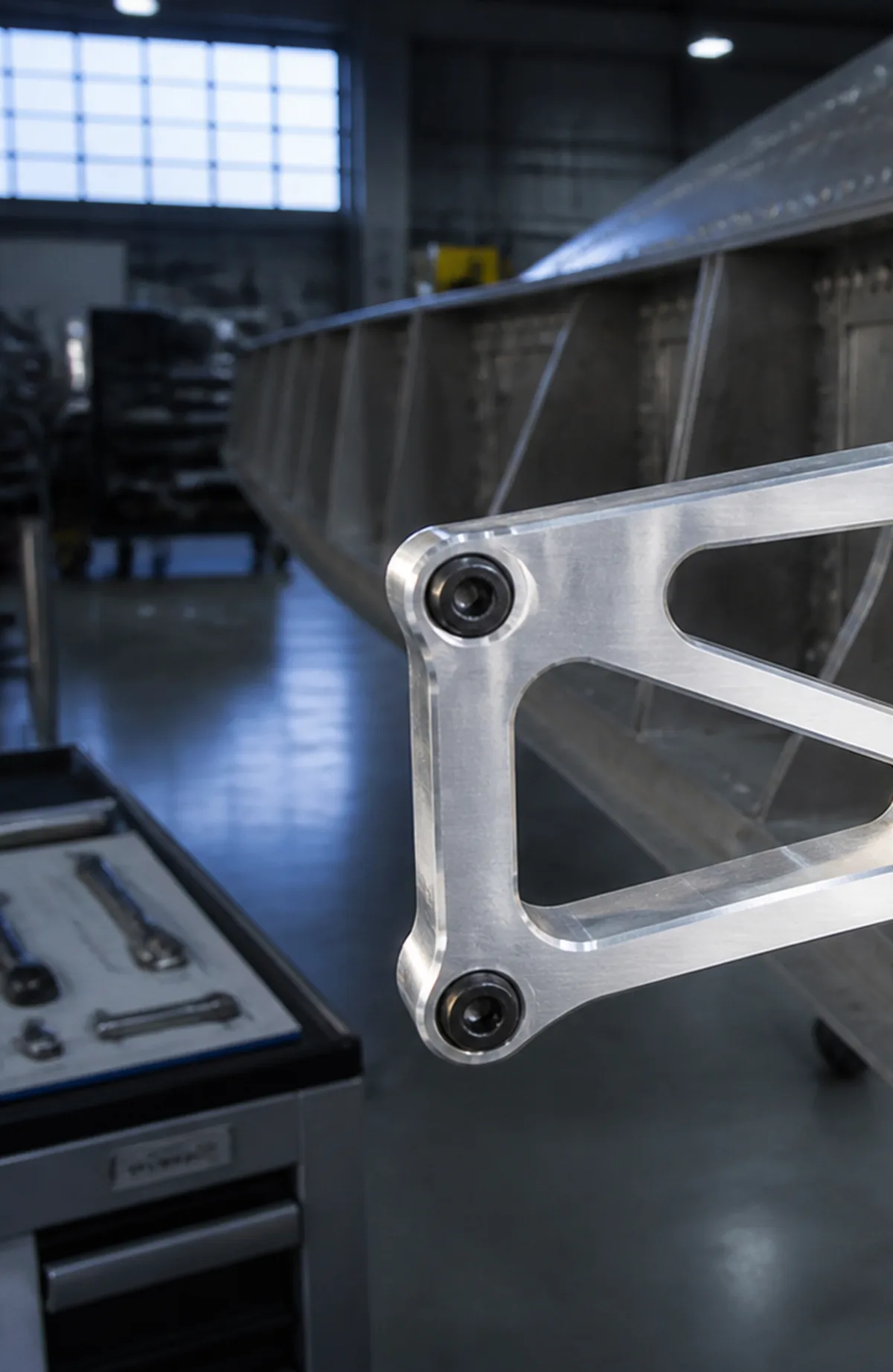 A machined aluminum bracket at an aircraft structure in the hangar.